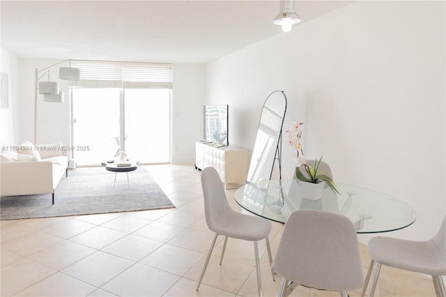 tiled dining area featuring a wall of windows