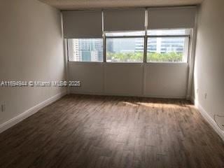 spare room featuring plenty of natural light and hardwood / wood-style floors