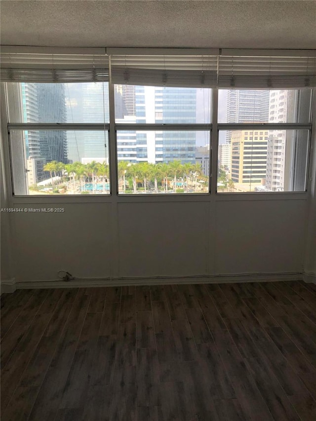 1420 Brickell Bay Dr Unit 1506D, Miami, FL 33131 - unfurnished room with dark wood-style flooring, a textured ceiling, and plenty of natural light
