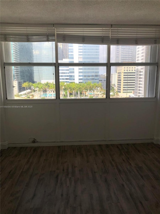 empty room featuring dark hardwood / wood-style flooring and a textured ceiling