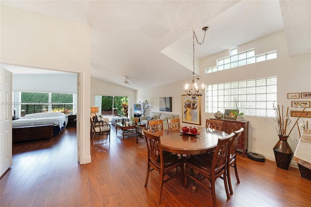 dining room featuring ceiling fan with notable chandelier, dark hardwood / wood-style flooring, lofted ceiling, and a textured ceiling