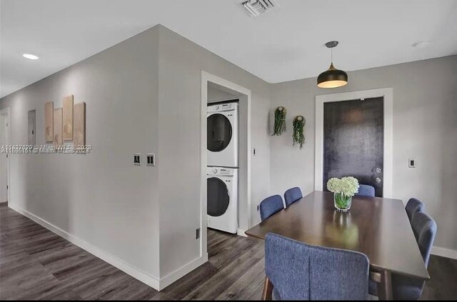 dining space featuring dark hardwood / wood-style flooring and stacked washer / dryer