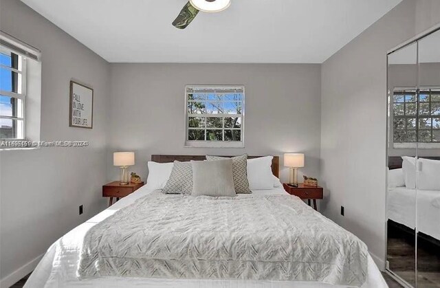 bedroom featuring ceiling fan, a closet, and multiple windows