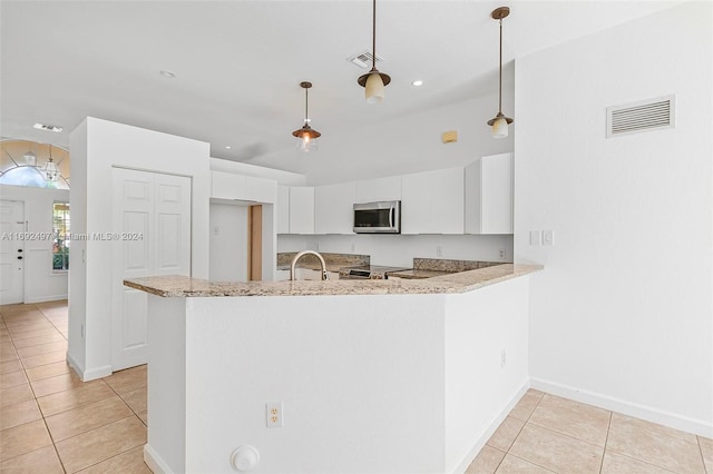 kitchen featuring kitchen peninsula, white cabinets, decorative light fixtures, and appliances with stainless steel finishes