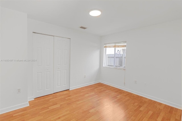 unfurnished bedroom with light hardwood / wood-style floors and a closet