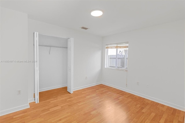 unfurnished bedroom with light hardwood / wood-style flooring and a closet