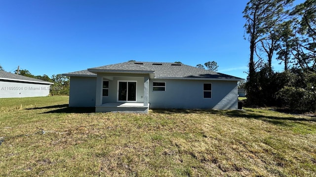 rear view of house featuring a yard