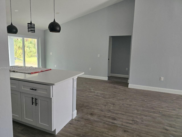 kitchen featuring decorative light fixtures, white cabinetry, dark wood-type flooring, and lofted ceiling