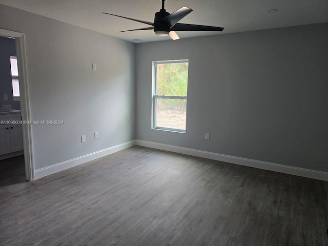 empty room with ceiling fan and dark hardwood / wood-style floors