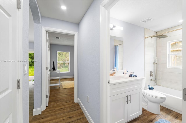 full bathroom featuring vanity, toilet, wood-type flooring, and tiled shower / bath combo