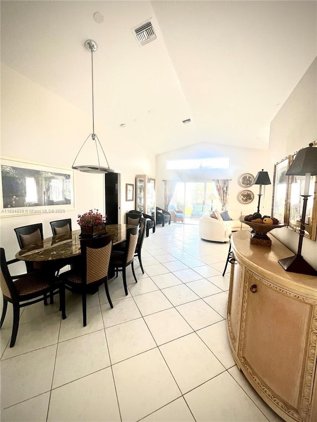 tiled dining space featuring vaulted ceiling