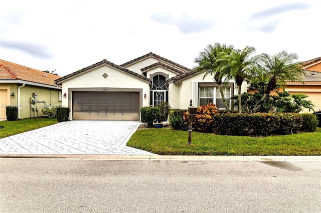 view of front of home with a garage and a front lawn