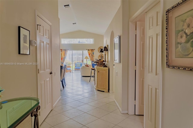 hall with vaulted ceiling and light tile patterned flooring