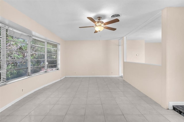 tiled spare room featuring ceiling fan