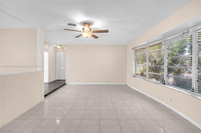 tiled empty room with ceiling fan