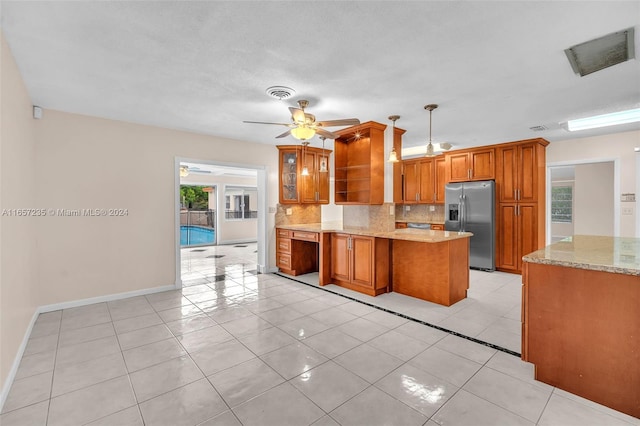 kitchen with pendant lighting, stainless steel refrigerator with ice dispenser, ceiling fan, light tile patterned floors, and tasteful backsplash