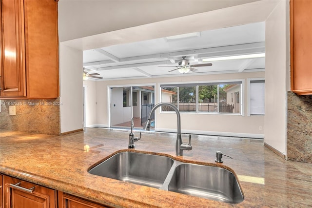 kitchen with ceiling fan, sink, coffered ceiling, beamed ceiling, and decorative backsplash