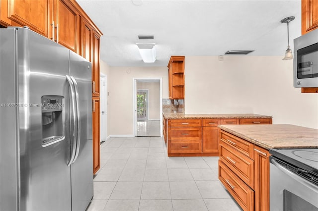 kitchen with pendant lighting, stainless steel appliances, light tile patterned floors, and light stone counters