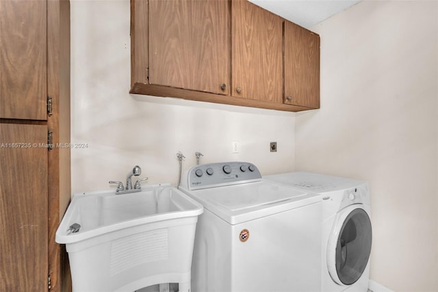 washroom featuring cabinets, independent washer and dryer, and sink