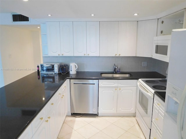 kitchen with decorative backsplash, white appliances, sink, light tile patterned floors, and white cabinetry