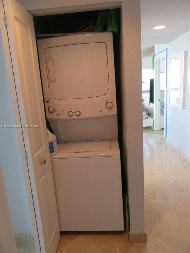 clothes washing area with stacked washer and clothes dryer