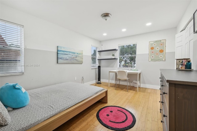 bedroom with multiple windows and light hardwood / wood-style flooring