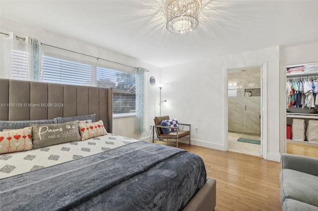 bedroom with hardwood / wood-style floors, a notable chandelier, a closet, and ensuite bath