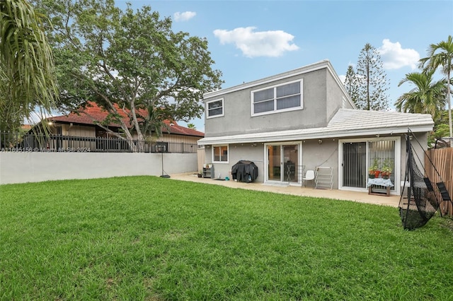 rear view of house with a lawn and a patio area