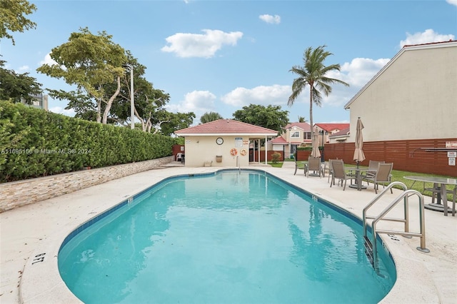 view of pool with an outbuilding and a patio