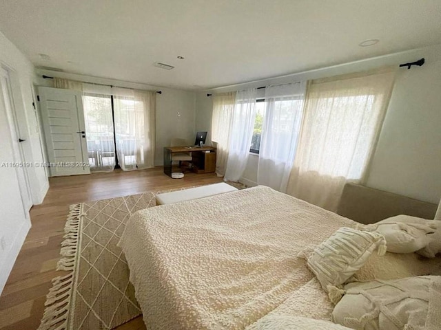 bedroom featuring wood-type flooring and multiple windows