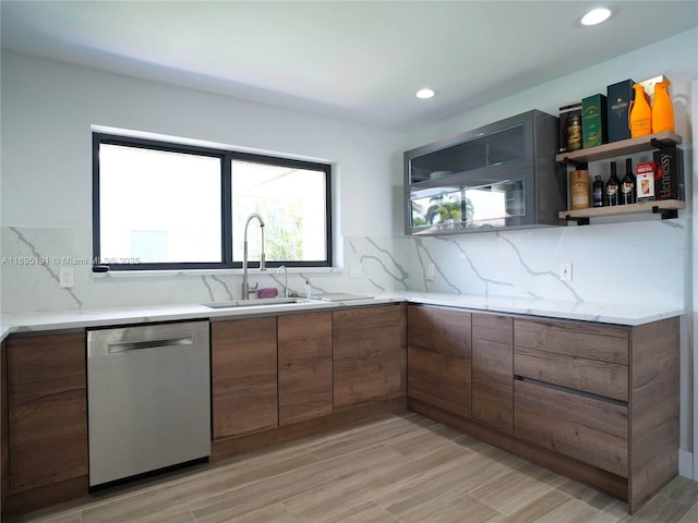 kitchen featuring dishwasher, backsplash, light hardwood / wood-style flooring, and sink