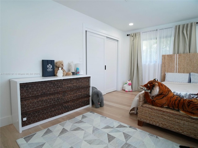 bedroom with light hardwood / wood-style flooring and a closet