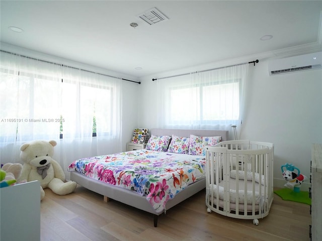 bedroom featuring an AC wall unit and hardwood / wood-style floors