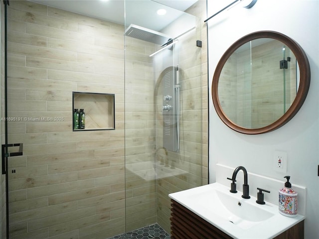 bathroom featuring a tile shower and vanity