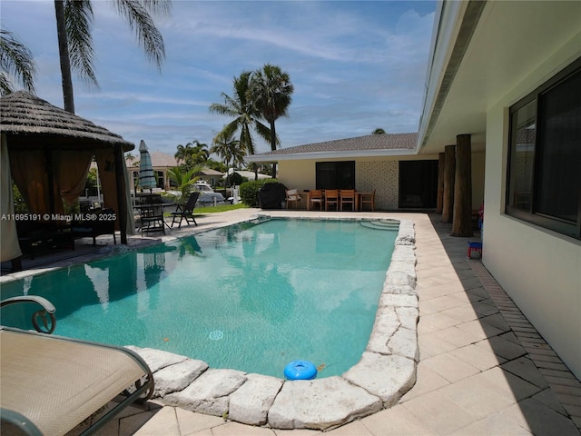 view of pool featuring a gazebo, a patio area, and a bar