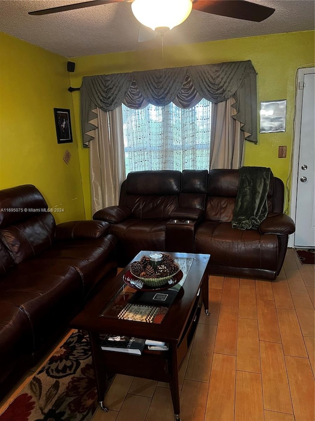 living room with ceiling fan, hardwood / wood-style floors, and a textured ceiling