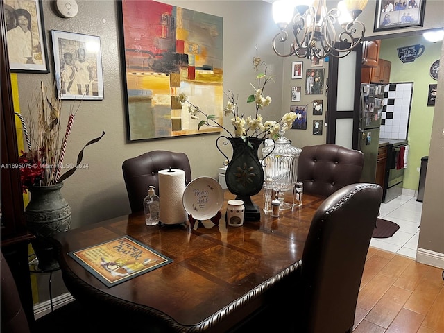 dining room with light wood-type flooring and an inviting chandelier