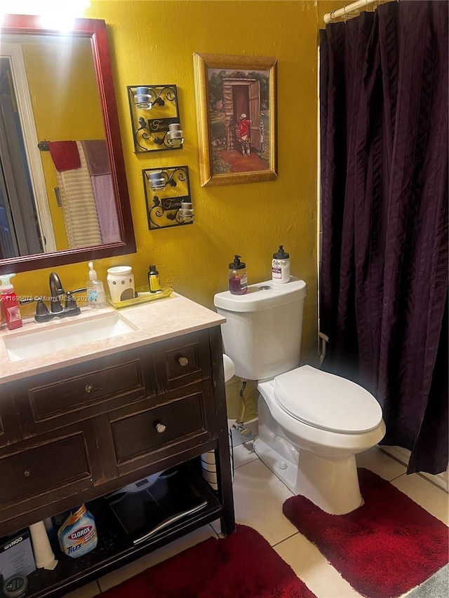 bathroom with tile patterned flooring, vanity, and toilet