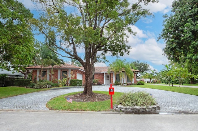 single story home with a garage and a front lawn