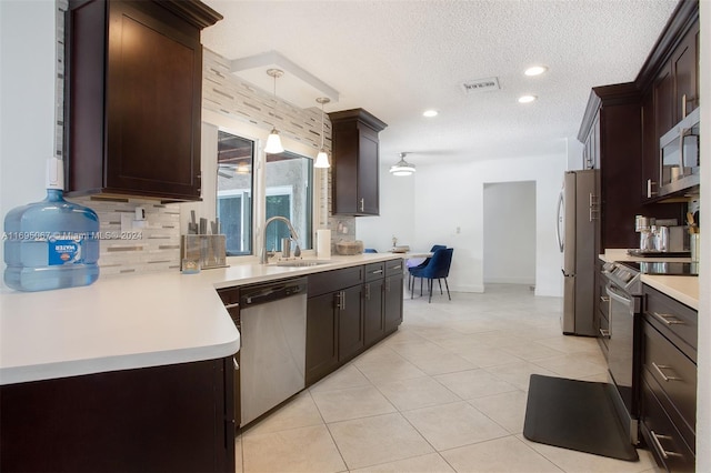 892 NW 83rd Dr, Coral Springs, FL 33071 - kitchen featuring stainless steel appliances, light countertops, backsplash, dark brown cabinetry, and a textured ceiling