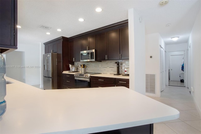 kitchen with backsplash, dark brown cabinetry, a textured ceiling, and appliances with stainless steel finishes