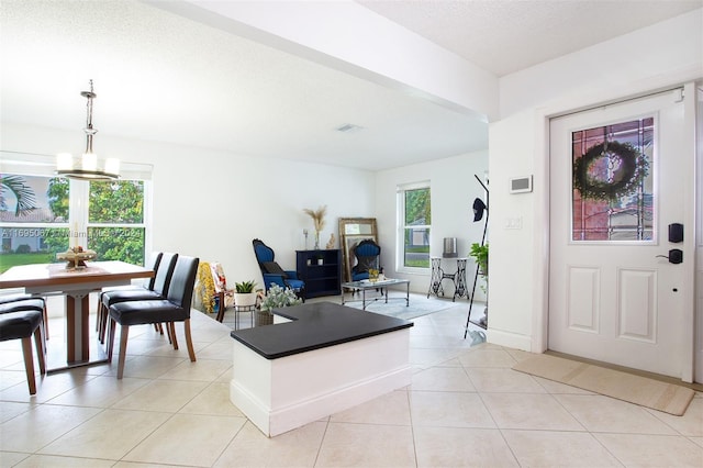 tiled foyer entrance with a notable chandelier and a textured ceiling