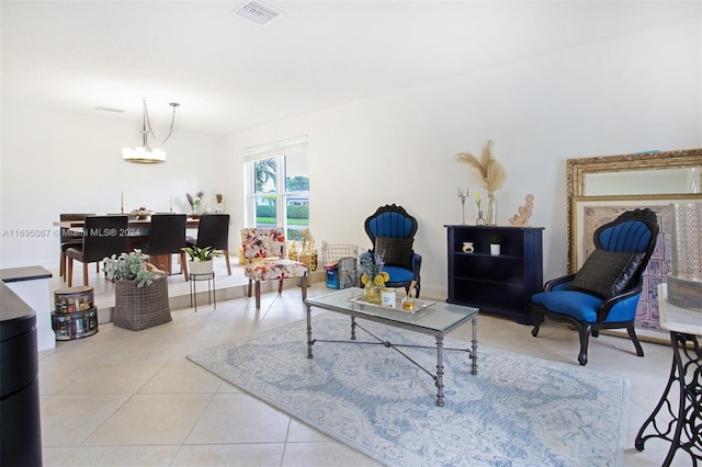 tiled living room featuring a notable chandelier