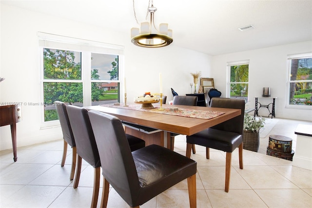 dining space featuring light tile patterned flooring and a chandelier