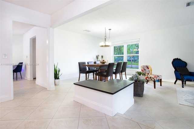 tiled dining area with an inviting chandelier