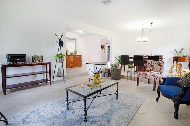 living room with light tile patterned floors and an inviting chandelier