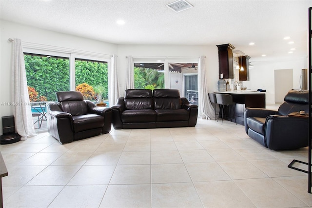 tiled living room featuring a textured ceiling and ceiling fan