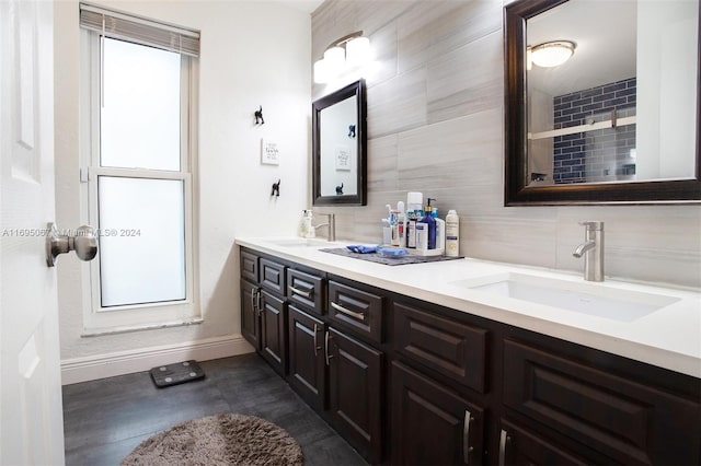 bathroom with tile patterned flooring, vanity, a healthy amount of sunlight, and tile walls