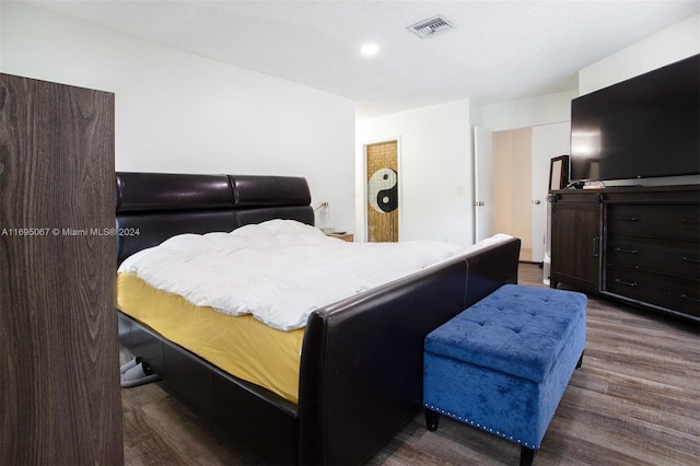 bedroom with dark hardwood / wood-style flooring and a textured ceiling