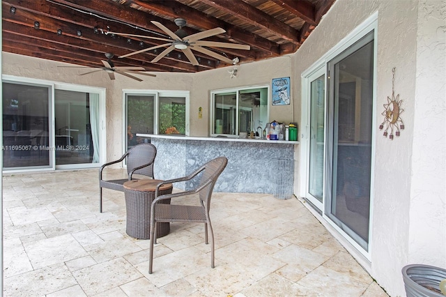 view of patio featuring ceiling fan and exterior bar